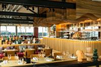 ボルドーにあるRenaissance Bordeaux Hotelのテーブルと椅子とバーのあるレストラン