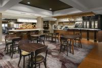 a restaurant with tables and chairs and a bar at Courtyard Chicago Bloomingdale in Bloomingdale