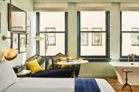 a bedroom with a couch and a table and windows at Hotel Per La, Autograph Collection in Los Angeles