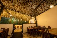 jadalnia ze stołami, krzesłami i oświetleniem w obiekcie Hotel Herb Garden w mieście Udawalawe