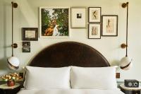 a bedroom with a bed with pictures on the wall at Hotel Per La, Autograph Collection in Los Angeles