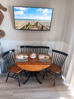 ein Esszimmer mit Tisch und Stühlen und einem Fernseher in der Unterkunft Shore Tails, LLC in Myrtle Beach