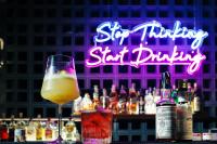 un bar avec une boisson et une enseigne au néon dans l'établissement Kamala Havana Hotel and Cafe, à Kamala Beach