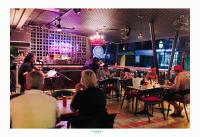 un groupe de personnes assises à des tables dans un restaurant dans l'établissement Kamala Havana Hotel and Cafe, à Kamala Beach