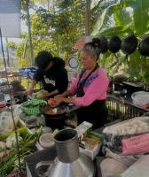 twee vrouwen die voedsel bereiden in een keuken met groepen voedsel bij Hula Hula Sunset, Dome in Pai