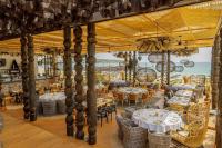 a restaurant with white tables and chairs and the ocean at Green Line Villa Sozopol in Sozopol