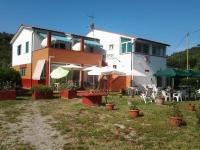 un edificio con mesas y sombrillas en un patio en Hotel Rustichello, en Marina di Campo