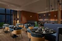 Un restaurante con mesas y sillas en una sala. en Courtyard by Marriott Paris Porte de Versailles, en Issy-les-Moulineaux