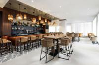 a restaurant with a bar with chairs and tables at AC Hotel by Marriott Honolulu in Honolulu