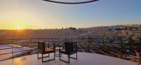 a balcony with two chairs and a view of the city at Jerash Hotel in Jerash