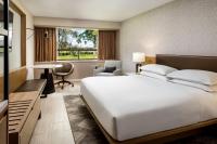 Un dormitorio con una gran cama blanca y un escritorio. en Sheraton Montreal Airport Hotel, en Dorval