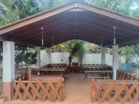 un pabellón de madera con mesas y bancos de madera en Lion King Jungle Cabanas, en Sigiriya