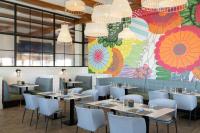 ein Restaurant mit Tischen und Stühlen und einem farbenfrohen Wandgemälde in der Unterkunft The Vinoy Resort & Golf Club, Autograph Collection in St Petersburg