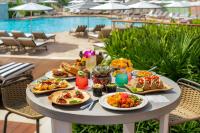 ein Tisch mit Tellern voller Essen neben einem Pool in der Unterkunft The Vinoy Resort & Golf Club, Autograph Collection in St Petersburg
