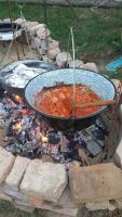 een grote pot soep boven een kampvuur bij Koppány Pines Rewild Escapes - Hungarian Village Vendeghaz in Koppányszántó