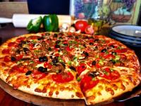a large pizza sitting on top of a table at Young's Motel in Tok