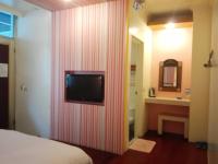 a room with a bed and a television on a wall at Cocos Hot Spring Hotel in Ruisui