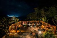 a group of people sitting at a table on a deck at night at Golo Nuk in Komodo Labuan Bajo Airport