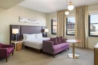 a hotel room with a bed and two chairs at Hotel Savoy Kansas City, Tapestry Collection by Hilton in Kansas City