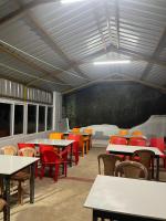 uma sala de aula com mesas e cadeiras e um quadro-negro em Lakshmi Flower Tech Resort em Yelagiri