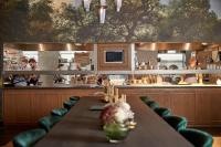 Un restaurante con una mesa y gente en la cocina. en Van der Valk Hotel Amsterdam - Amstel, en Ámsterdam