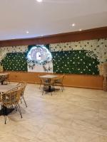 een kamer met tafels en stoelen en een muur met bloemen bij Pridehomes in Nairobi