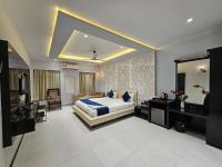 1 dormitorio con 1 cama extragrande y espejo en Hotel MK Vivanta, en Gwalior