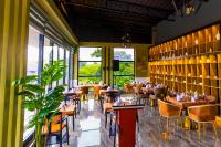 een restaurant met tafels en stoelen en grote ramen bij T-Stone Apartments Kigali-Kimihurura in Kigali