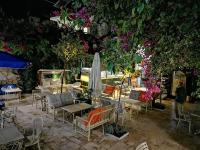 een patio met tafels, stoelen en bloemen bij Patron Hotel in Antalya