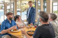 um grupo de pessoas sentadas ao redor de uma mesa comendo comida em Ozone Hotel Kangaroo Island em Kingscote