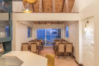 a dining room with tables and chairs and a balcony at Echor Backwoods Villa Narkanda in Nārkanda