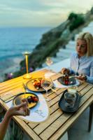 una mujer sentada en una mesa con platos de comida en Blue Sand Boutique Hotel & Suites, en Agali