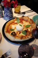 a pizza on a plate on a table at Hotel AMANO Grand Central in Berlin
