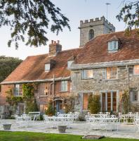 Un lugar para bodas con mesas y sillas frente a un edificio. en Priory Wareham, en Wareham