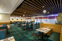 Un comedor con mesas y sillas y un bar. en Metropark Hotel Kowloon, en Hong Kong