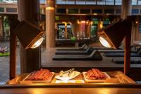 Un buffet con carnes y comida en una mesa. en Santhiya Koh Phangan Resort and Spa, en Thong Nai Pan Noi