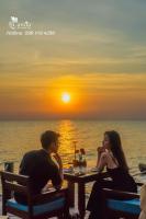 um homem e uma mulher sentados à mesa em frente a um pôr-do-sol em Camia Resort & Spa em Duong Dong