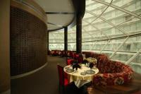 a dining room with a table and red chairs at Rajhans Belliza By Honest Homes in Surat