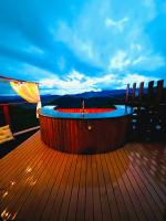 a hot tub on the deck of a boat with an umbrella at Chalé Boutique Spa- Sauna seca, Jacuzzi , Rede suspensa in Campos do Jordão