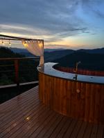 a hot tub on a deck with a view of the mountains at Chalé Boutique Spa- Sauna seca, Jacuzzi , Rede suspensa in Campos do Jordão
