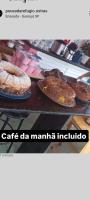 una mesa con dos platos de pasteles y tartas en Suíte Luxo Refúgio das Ostras, en Guarujá