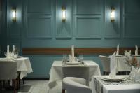 タシュケントにあるGreen Park Hotelの青い壁のダイニングルーム(白いテーブル、椅子付)