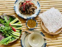 uma mesa coberta com pratos de comida com pauzinhos em GOLDEN LOTUS SPA & HOMESTAY em Ấp Thiện Phước