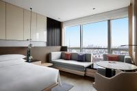 瀋陽市にあるShenyang Marriott Hotelのベッドとソファとテーブルのある寝室