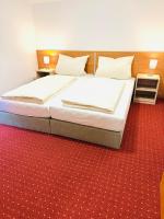 Cama en habitación con alfombra roja en Hotel Am Weyerhof, en Kerpen