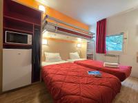 a hotel room with two beds with red sheets at Premiere Classe Evry Sud - Mennecy in Ormoy