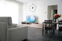 a living room with a couch and a table and a clock at Urban Flat in Lugano