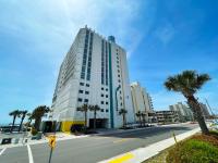 ein hohes weißes Gebäude in einer Stadtstraße mit Palmen in der Unterkunft Seaside Resort in Myrtle Beach