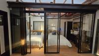 ein Schlafzimmer mit einem Bett in einem Zimmer mit Glastüren in der Unterkunft Jian Hanok in Seoul