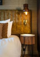 a bed with a side table next to a bed at Boutique Hotel De Smulpot in Den Burg